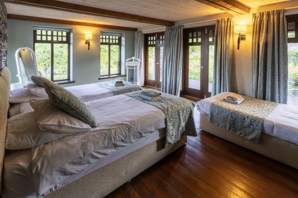 Double bedroom with a wooden floor and a view over the garden