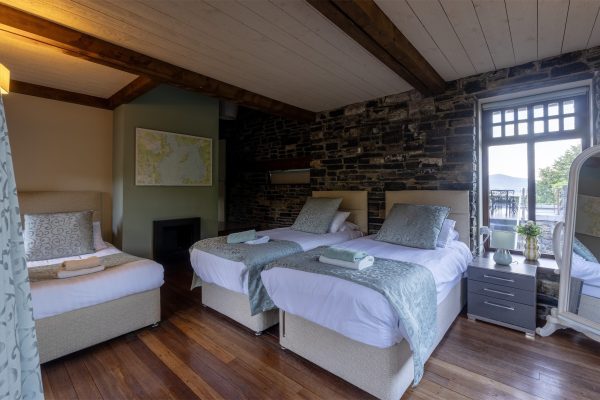 Twin bedroom with an exposed stone feature wall