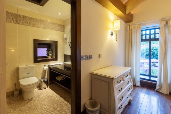 En-suite with a WC and chest of drawers beside a garden window