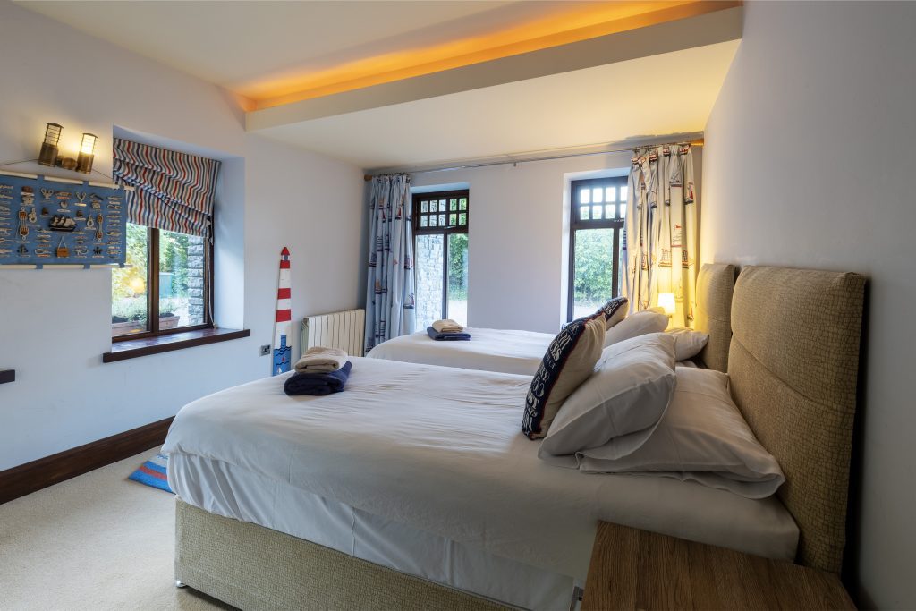 Double bedroom with a padded headboard and roman blinds