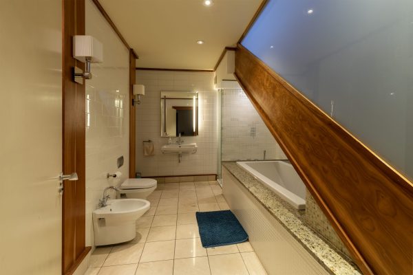 Bathroom with a bath set under a sloping ceiling
