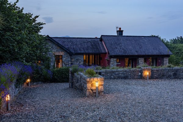 The lodge at dusk with lanterns along the driveway