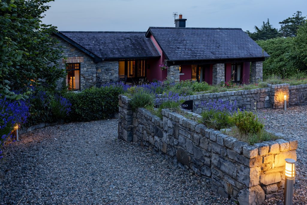The lodge at dusk above its stone garden wall